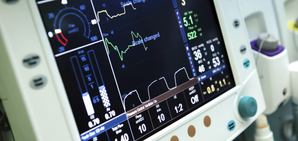 A piece of medical equipment that is monitoring a person out-of-frame's vitals.